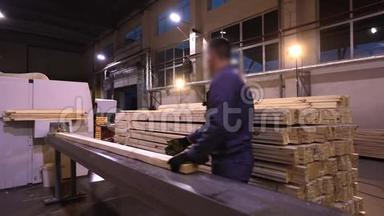 一个男人在锯木厂工作，一个现代锯木厂的工作流程。 工业内部木工厂